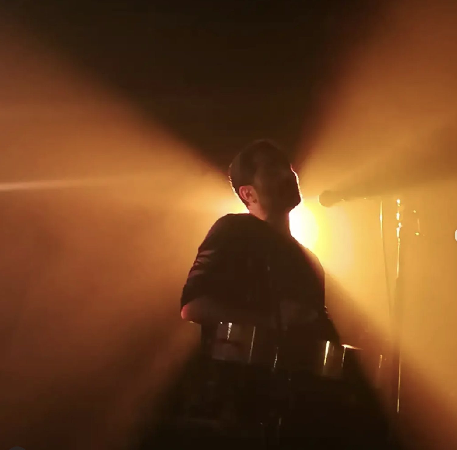 Silhouette of a performer under stage lights