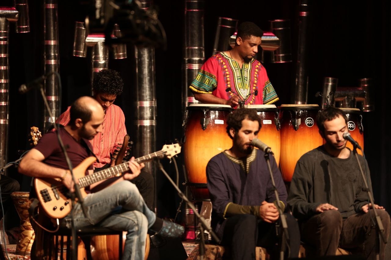 Kamakan band performing with congas and bass on stage